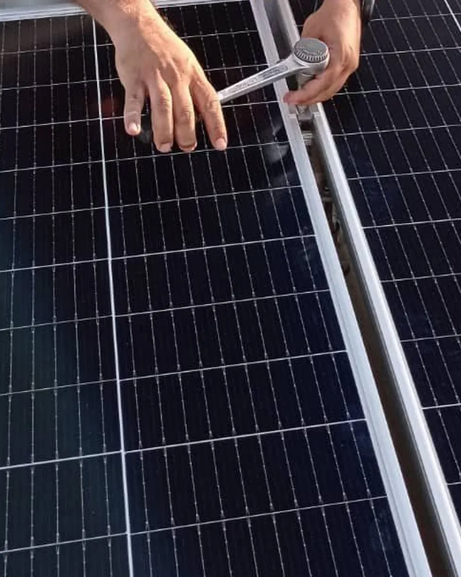 Instalador fixando com chave catraca a estrutura de sustentação de um módulo fotovoltaico