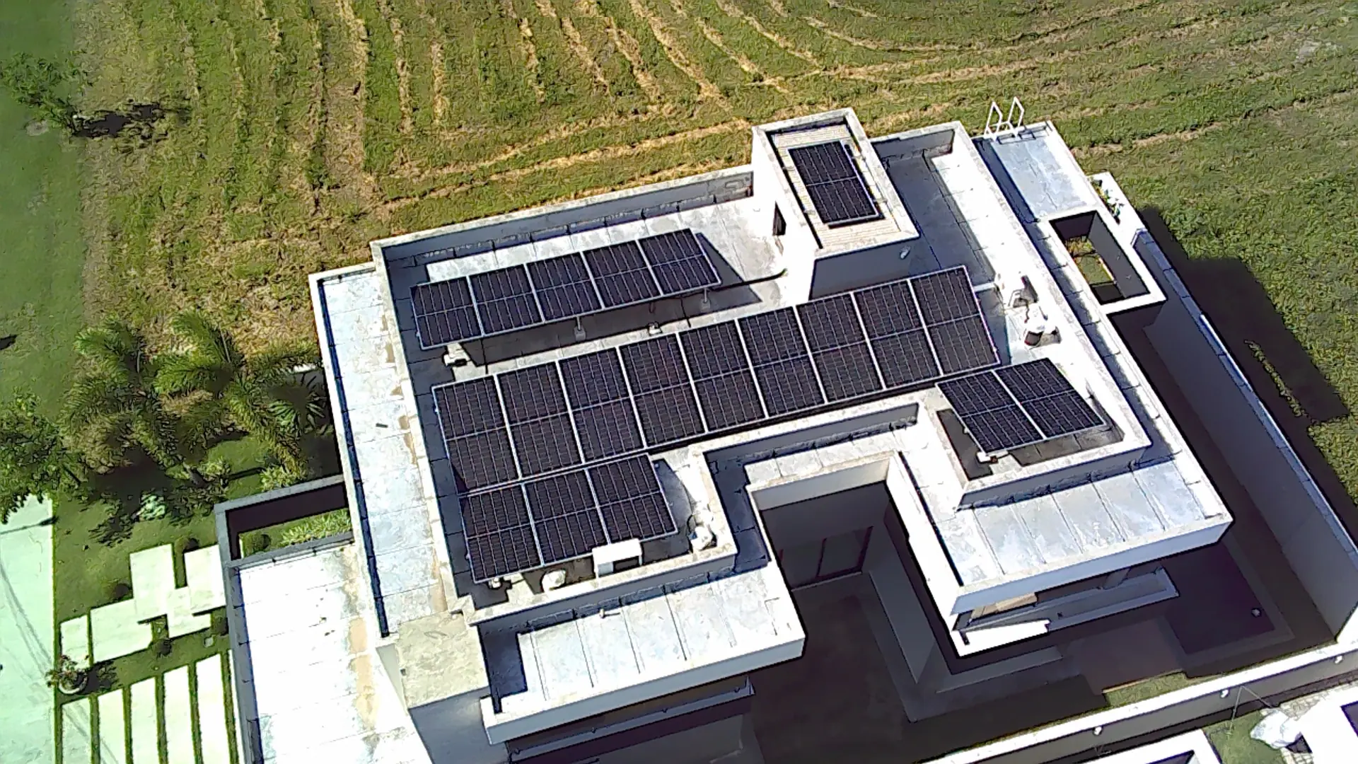 Vista aérea de usina fotovoltaica cobrindo a laje de uma residência de grande porte