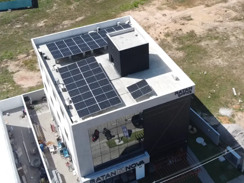 Vista aérea do edifício Ratan Office com a usina solar instalada na laje, em três conjuntos de módulos fotovoltaicos